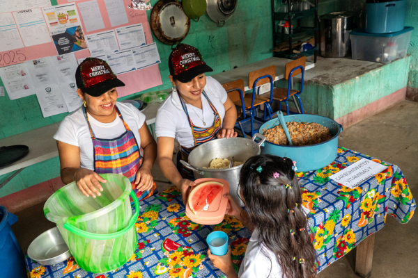 School cooks in Guatemala serving a meal to a child