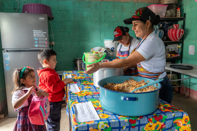 A child receiving a school meal from a cook